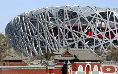 在古庙的映衬下，现代感十足的国家体育场“鸟巢”熠熠生辉。
