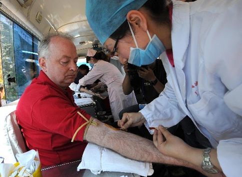 南京，2008年5月14日 外国友人为地震灾区献血 5月14日，53岁的加拿大友人迈克尔·普尔在流动献血车上义务献血。 