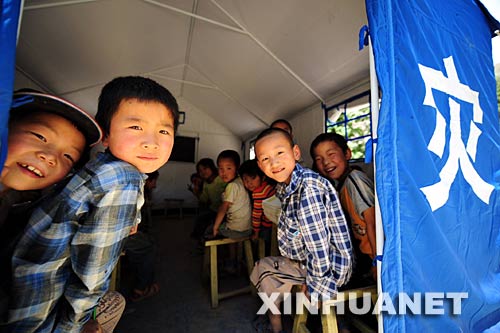 6月2日，在甘肃省陇南市武都区地震灾区，石门乡小山坪小学的学生在课间休息时从帐篷教室里向外张望。 据介绍，经过社会各界及灾区群众的共同努力，甘肃陇南灾区学校的复课工作取得很大进展。截至6月2日18时，陇南市已有1911所学校完全复课，229所学校部分年级复课，复课学校占全部学校的74%，34.4万名学生重新走入课堂。 新华社记者 张锰 摄 