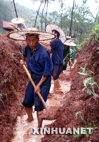 6月18日，江西省兴国县江背镇郑塘村村民冒雨挖水渠排水。 17日8时至18日8时，江西部分地区下了中到大雨，局部大暴雨，主雨区在赣南。江西省要求全省各地必须按照防汛三级应急响应要求，继续做好各项防汛工作。 新华社发(李人庆 摄) 