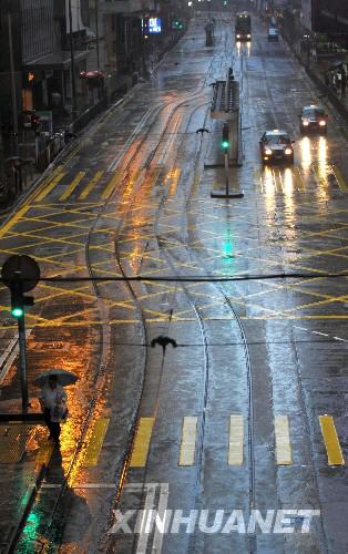 6月25日，市民和车辆在雨中行进。由于台风“风神”迫近香港，香港天文台6月24日22时45分发出8号风球（暴风信号），并于6月25日6时发出红色暴雨警告信号。 