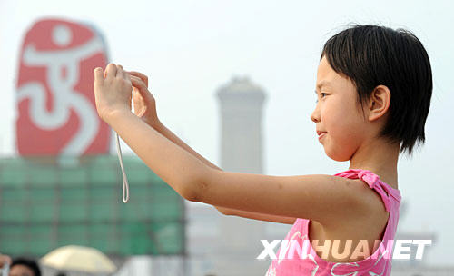 7月26早晨，一名来自山东潍坊的小女孩在天安门广场的“中国印”前拍照。