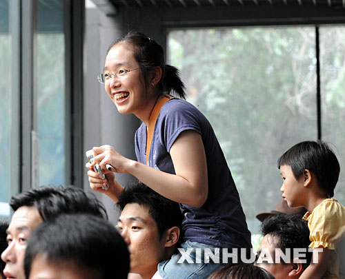7月29日，游客在观看“奥运熊猫”。来自卧龙的8只“奥运熊猫”自6月5日亮相以来，北京动物园熊猫馆已经陆续接待100余万游客。 新华社记者 李文 摄 