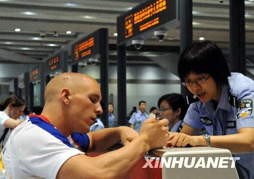 8月25日，边检民警在为奥运大家庭成员办理出境手续。 新华社记者唐召明摄