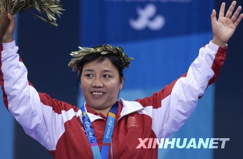 这是47岁的中国广西选手张小玲在雅典残奥会冠军领奖台上向观众致意的资料照片。 新华社发 