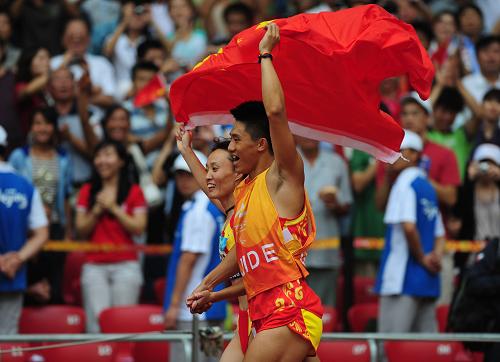 9月9日，中国选手吴春苗（左）与领跑员在比赛后绕场庆祝。