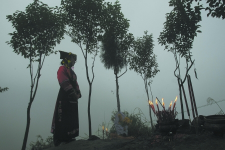北川，一名羌族女孩正在山顶为地震死难者默哀。