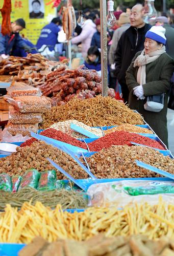 南京夫子廟正月用品市場が1月1日にオープンし、各地の特色ある食品や農産品、祝祭日の飾り物、民間工芸品、季節用品など品ぞろいが豊富なことから、多くの市民が買い物に訪れた。写真は正月用品市場で買い物をする南京の市民（1月1日）。