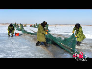 魚網(wǎng)の動きにそって多くの魚が元気よく氷の穴から跳ね出し、水しぶきが漁民の靴や上著、観光客の體、顔、カメラのレンズまで飛び散る。黒龍江省のドルボド?モンゴル族自治県では18日から冬の漁が始まり、漁民たちは伝統(tǒng)的な湖の神を祭る方法で平穏無事を祈る。