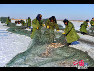 魚網(wǎng)の動きにそって多くの魚が元気よく氷の穴から跳ね出し、水しぶきが漁民の靴や上著、観光客の體、顔、カメラのレンズまで飛び散る。黒龍江省のドルボド?モンゴル族自治県では18日から冬の漁が始まり、漁民たちは伝統(tǒng)的な湖の神を祭る方法で平穏無事を祈る。