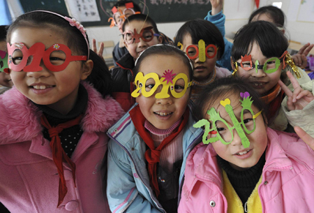 Students pose for a photo wearing spectacle frames shaped in the number '2010' to welcome the upcoming New Year at a primary school in Hefei, Anhui province December 30, 2009.[China Daily/Agencies]