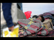 インドのニューデリーで毛布に包まっているのは身寄りのない子供。インド政府の関係者によると、インド北部の地域では寒波の影響で少なくとも40人が死亡し、政府は4日に学校を休校し暖房用燃料を配給せざるを得なかったという（1月4日）