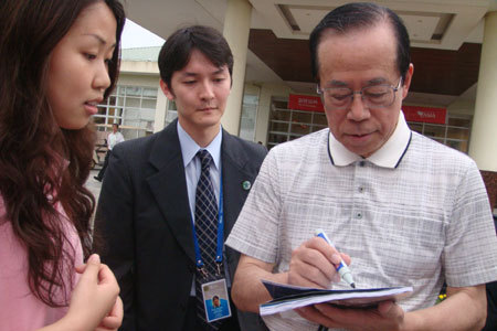 『新財富』誌記者の求めに応じてサインする福田康夫・日本元首相