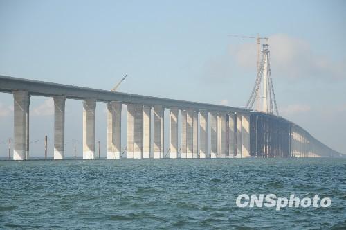  资料图：2010年7月26日，青岛海湾大桥建设现场，建设者冒着高温战斗在建桥一线，大桥像一条海上蛟龙，雄姿已经显现。  中新社发俞方平 摄