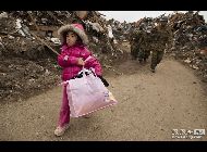 岩手県陸前高田市。津波で崩れた家から物を探し出した女の子(5歳)