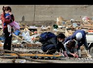 岩手県宮古市。自宅の廃墟の下敷きになった母親と3歳の息子の遺体を見て、涙で言葉を詰まらせる女性。