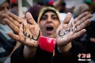リビア東部のベンガジで行われた多国籍軍の対リビア攻撃を支持する活動で、「リビアを愛する」と書いた手を挙げる女性