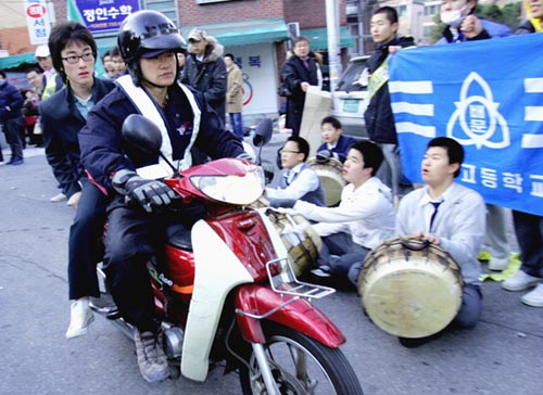 韓国のソウル市で、オートバイで息子を試験会場に送り届けた父親