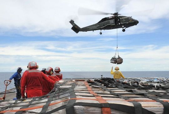 資料写真:空母で救援物質を運ぶ米軍