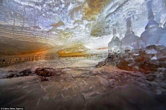 抓拍冰世界：这张惊人照片展示了俄罗斯列宁格勒州东部提安尤卡思河冰面下的神秘世界。这些气穴深2英尺，有一些透明圆柱和晶体形状，自然光使里面形成不同颜色。