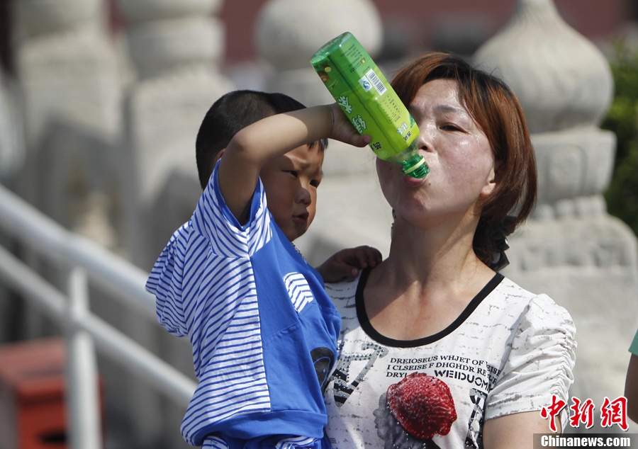 北京持续高温 孩子给妈妈喂水消暑