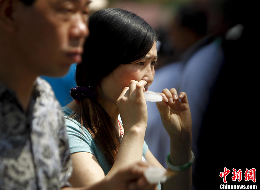 北京持续高温 游客吃冰棒解暑