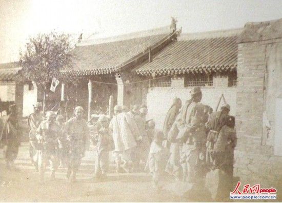 在金州城內原副都統的衙門前，大清國的貧民們接受施粥。1894年11月10日，從軍攝影班攝影。