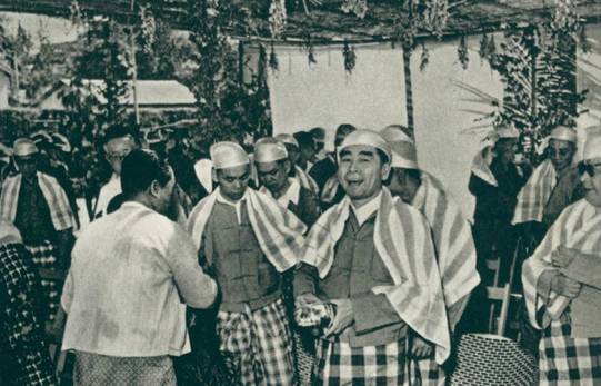 1960年4月，周恩来访问缅甸时，身着缅甸民族服装，手持银碗，同缅甸人民欢庆泼水节。[资料图]