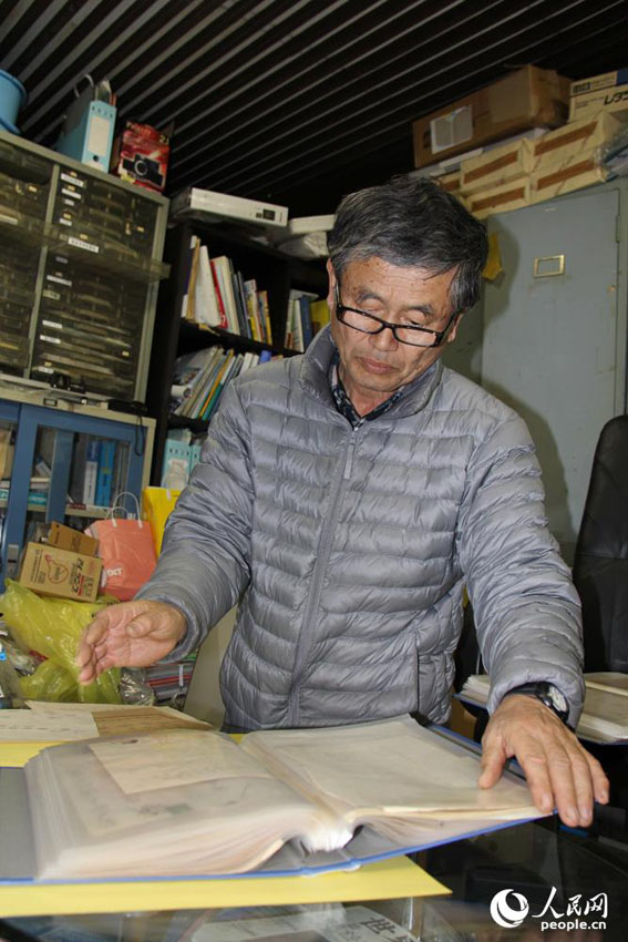 在堆满五金的办公室里，田中信幸在查看父亲留下的300多封信件。 人民网记者 刘军国摄