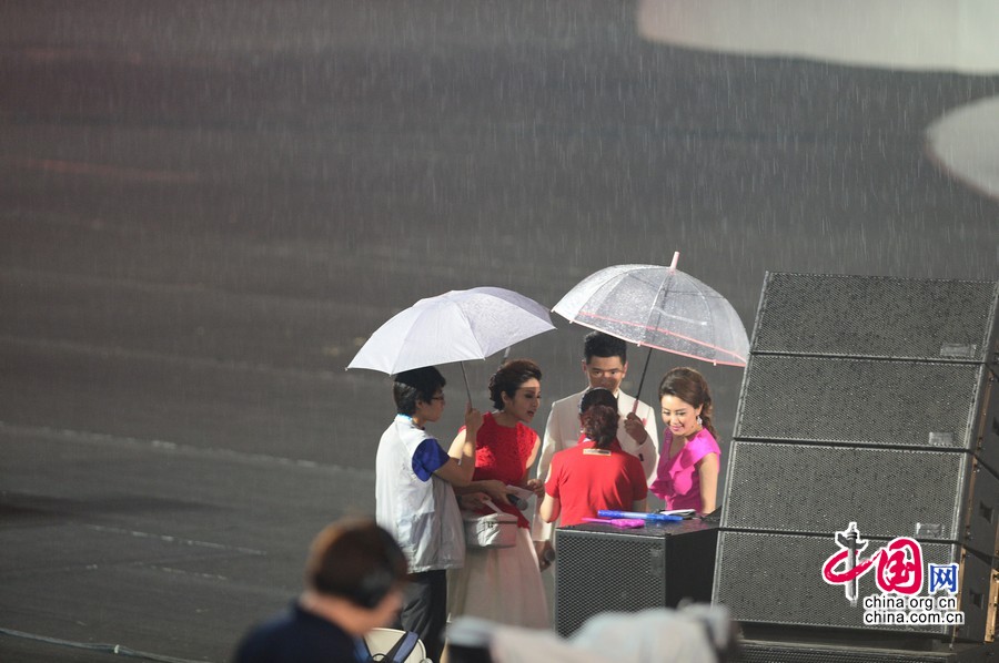 2014年8月16日晚20点，大雨突袭第二届夏季青年奥运会开幕式现场，组委会工作人员迅速在开幕式场地上覆盖雨布，主持人也打起早已准备好的雨伞继续节目进行。