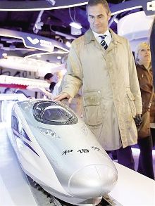 图为在意大利米兰世博会中国企业联合馆，一名参观者观看中国南车生产的“和谐号”动车组模型。 新华社发