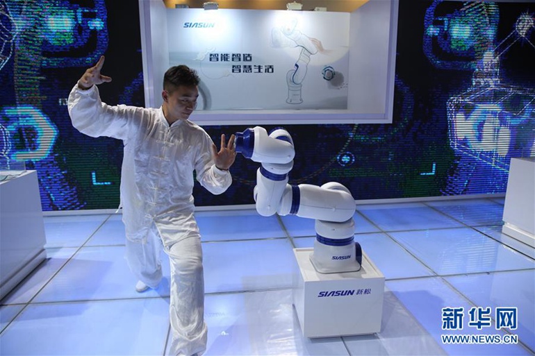 11月24日，一名太极表演者在和柔性多关节灵活移动的机器人一起表演太极。 新华社记者 金立旺 摄 