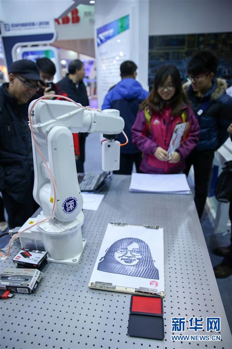  11月24日，可以对参观者进行面部识别并绘图的机器人在演示绘图过程。 新华社发（章斌 摄） 