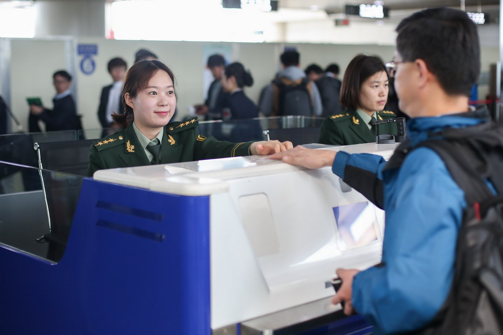 3月4日，女子旅检科检查员李燕霞热情为旅客办理通关手续。新华社发（解豪 摄）