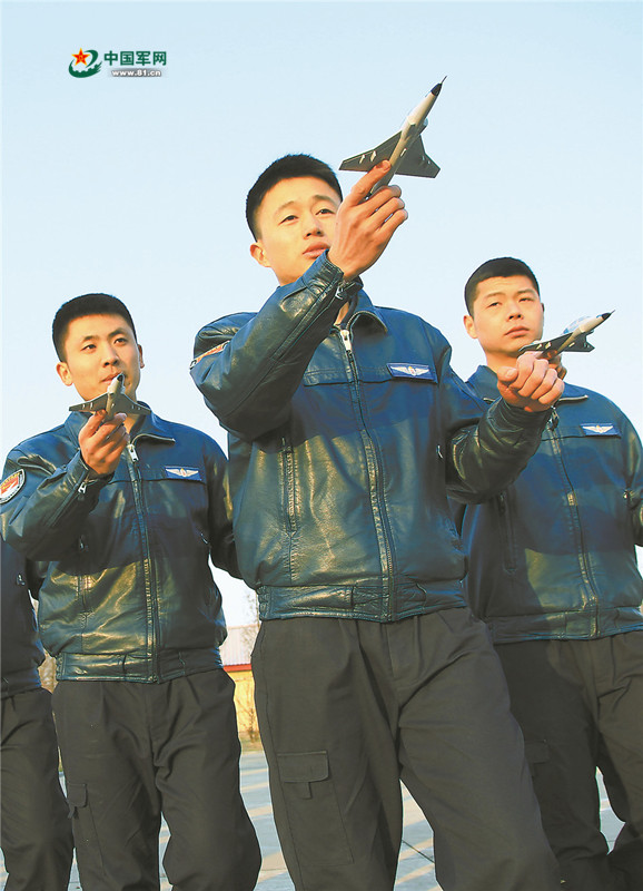张灿（中）与战友进行地面协同，模拟编队飞行。