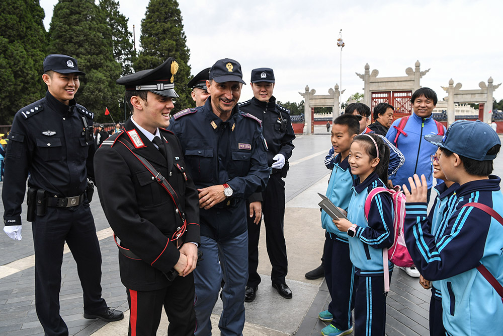 4月25日，在北京天坛进行中意警务联合巡逻的警员与中国小学生们交流。