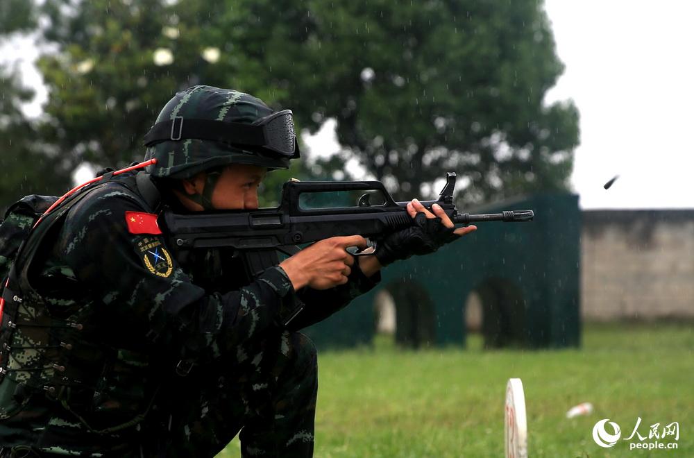 特战队员在雨中展开步枪快速精度射击。