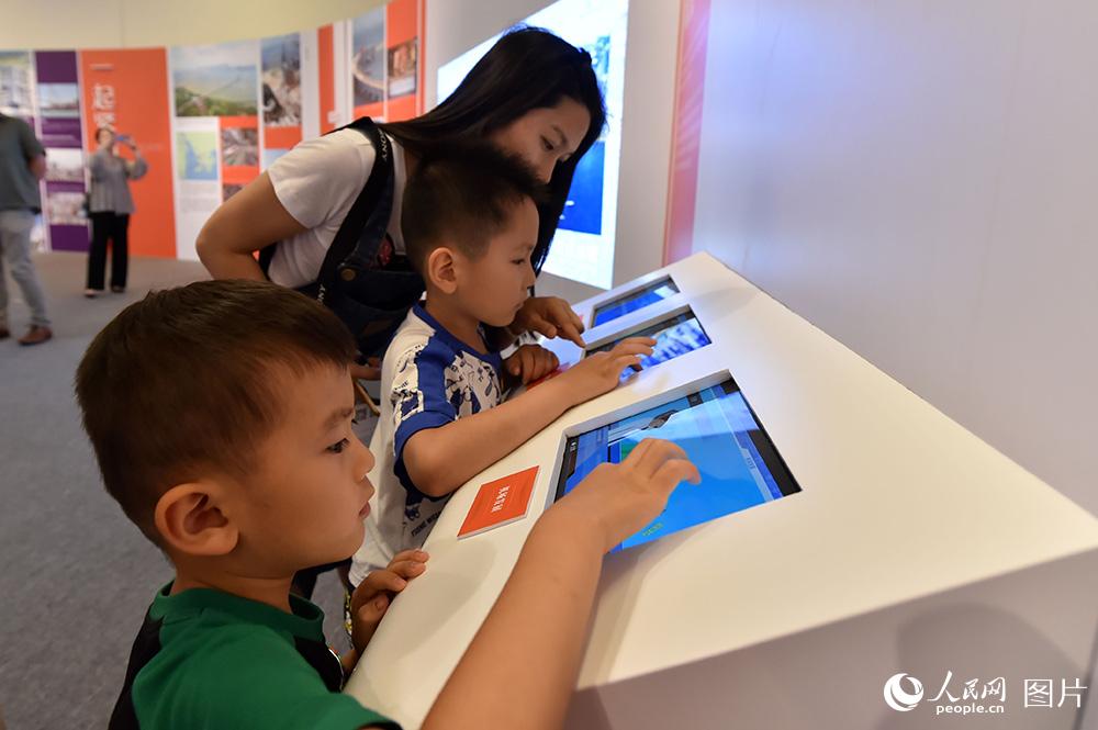 6月28日，小朋友在展览现场参与互动游戏。（人民网记者 翁奇羽 摄）