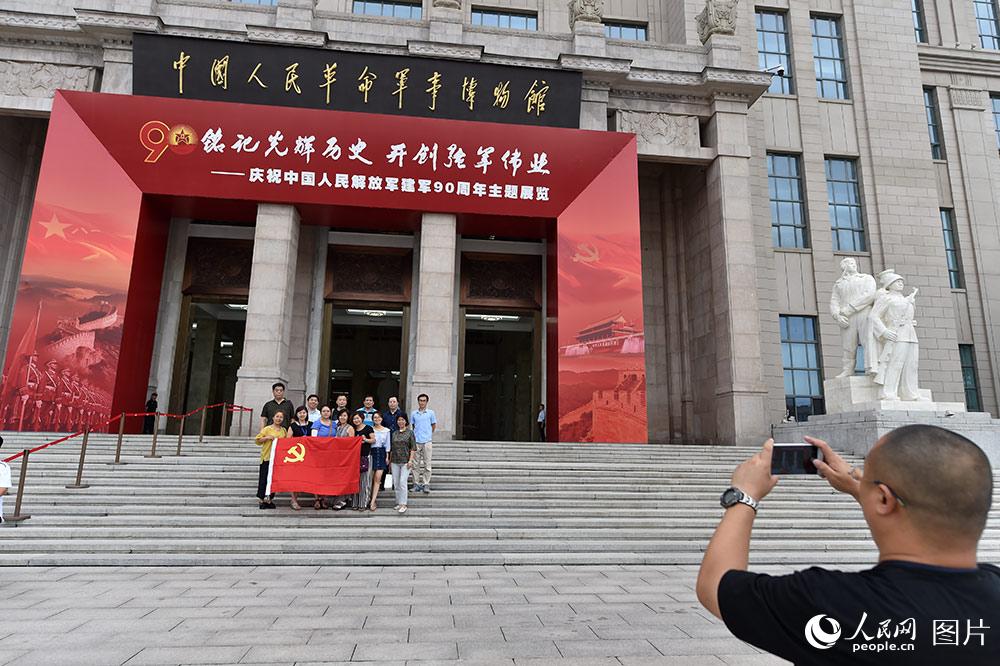 7月24日，观众在“铭记光辉历史　开创强军伟业——庆祝中国人民解放军建军90周年主题展览”前合影。（人民网记者 翁奇羽 摄）