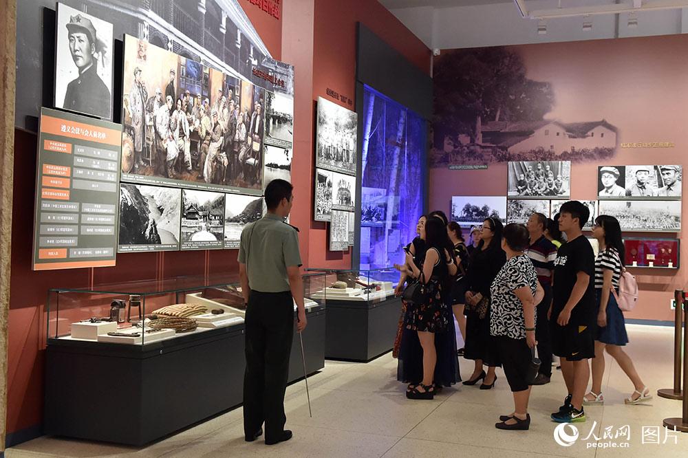 7月24日，在“铭记光辉历史　开创强军伟业——庆祝中国人民解放军建军90周年主题展览”上，解说员在为参观者讲解。（人民网记者 翁奇羽 摄）