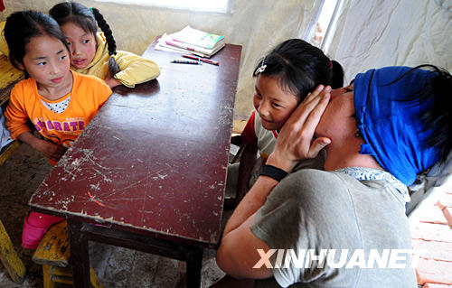 29 мая, американский доброволец Ван Цзы разговаривает с ученицей в школе, расположенной в палатке.