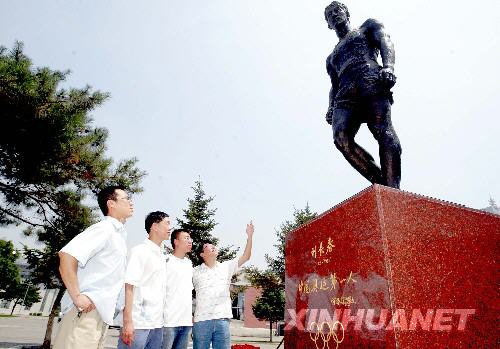16 июня, несколько студентов в Северо-Восточном Университете Китая рассматривают статую Лю Чанчуня.