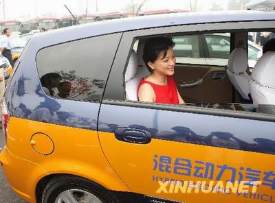 Представитель имиджа Олимпиады Ян Лань на такси, работающем на смешанных энергиях.