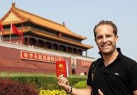 Иностранец фотографируется на площади Тяньаньмэнь с книгой цитат Мао Цзэдуна в руке