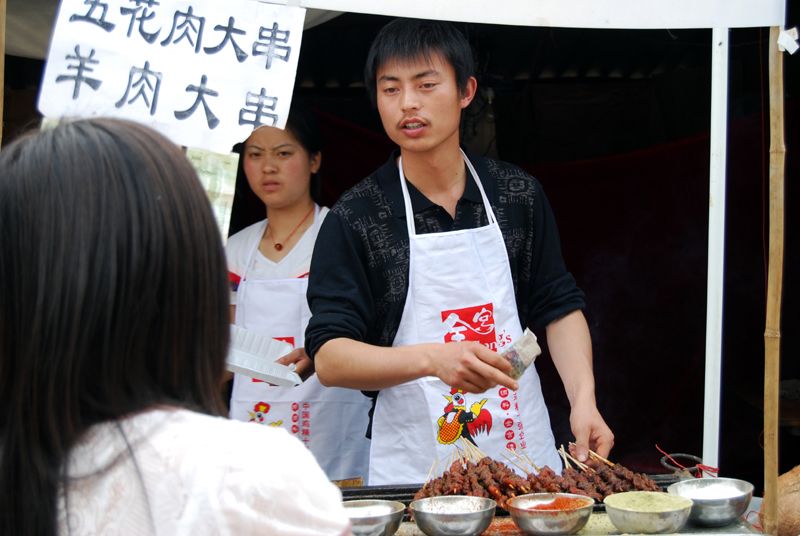 Один из уличных торговцев, продававших различные товары тысячам людей, посетившим уезд Бэйчуань 11 мая 2009 года