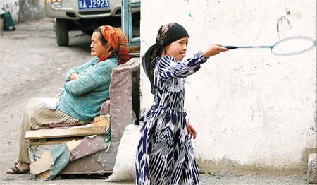 Уйгурская девочка играет в бадминтон в спокойном городе Урумчи во вторник. Как бы там ни было, Аль-Каида вынесла свои угрозы в других местах.