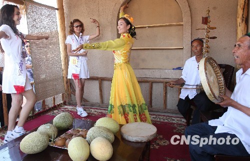 Девушки уйгурской национальности СУАР с песнями и танцами отмечают открытие Фестиваля хамийских дынь 
