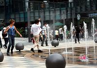Люди, забавляющиеся с фонтанами на улице Саньлитунь в Пекине