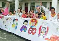 Молодые люди разных национальностей Китая рисуют длинную картину, посвященную 60-летию КНР