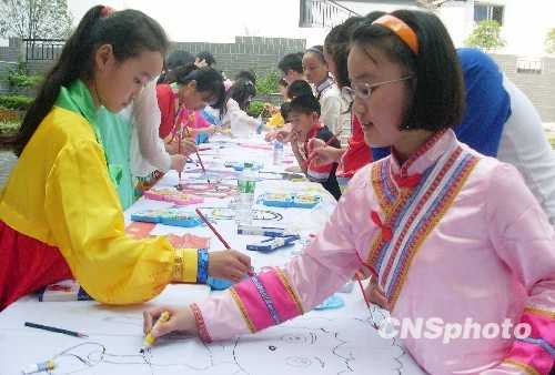 Молодые люди разных национальностей Китая рисуют длинную картину, посвященную 60-летию КНР 